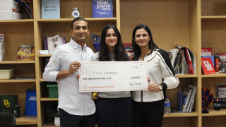  student and parents holding big check 